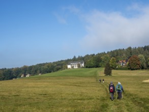 Landscape with meadows, forest and hiking group, Zittau Mountains, Saxony, Germany