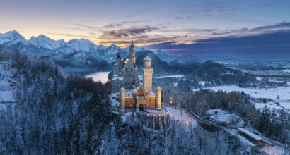 Neuschwanstein Castle at dusk in winter with mountain scenery, Schwangau near Füssen, Ostallgäu,
