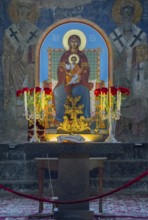 Icon of the Mother of God and Child Jesus surrounded by candles and flowers on an altar, Akhtala