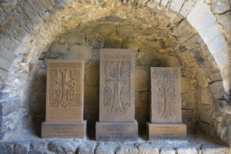 Three khachkars with detailed stone carving in a stone niche, cross stones, Akhtala monastery,