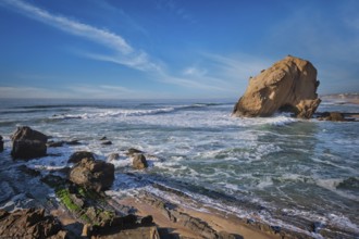 Penedo do Guincho, a large boulder rock arch at Praia da Santa Cruz, Portugal, with ocean waves and