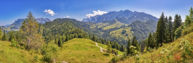 Green hills and impressive mountain range under clear sky, Austria, Wilder-Kaiser, panorama