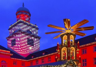 The Christmas market with the mulled wine pyramid and the illuminated town hall in the evening,