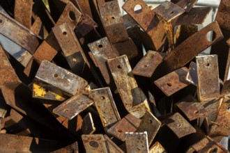 Close-up of pile of old rusted steel support brackets with bored holes, Quebec, Canada
