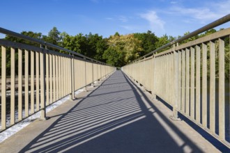 Wide angle view of pedestrian walkway on top of water flow control Moulin Neuf dam over Des