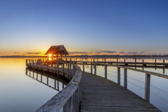 Wooden jetty on Lake Hemmelsdorf / Hemmelsdorfer See at sunrise in spring near Lübeck,