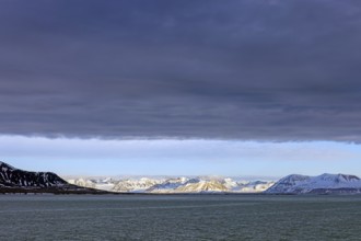 Snow covered mountains and glaciers debouching into Lilliehöökfjorden, fjord branch of Krossfjorden