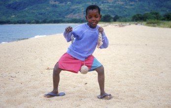 Little boy posing with caught fish for camera, Chitimba, Lake Malawi, Africa, July 2000, vintage,