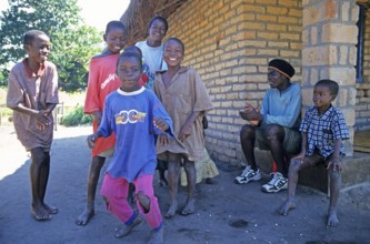 Local children dance happily to music in a village near Kande, Lake Malawi, Malawi, Africa, July