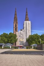 St. Boniface Catholic Church, scaffolding, renovation, concrete paving square, trees, blue sky,