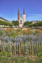 Park, flower bed, plants, wooden fence, Waterloo monument, St. Boniface Catholic Church,