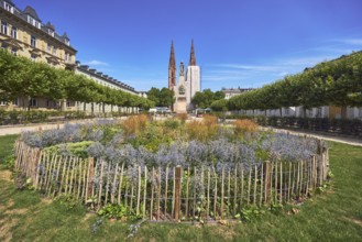 Park, round flower bed, plants, wooden fence, Waterloo monument, St. Boniface Catholic Church,