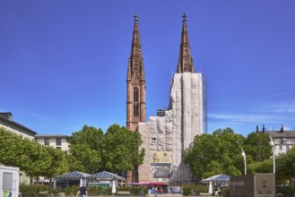 St. Boniface Catholic Church, scaffolding, renovation, concrete paving square, trees, blue sky,