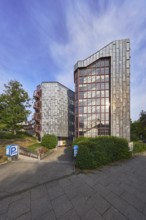 Theatre car park, modern architecture, entrance, access, sidewalk, trees, bushes, lawn, blue sky,