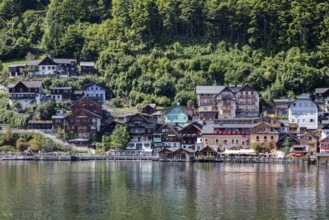A, Hallstatt, Houses of various colors along a calm body of water, surrounded by trees, Austria