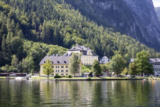 A, Hallstatt, A yellow lakeside building surrounded by woodland and majestic mountains, Austria