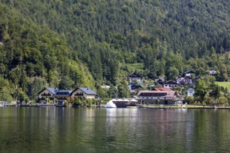 A, Hallstatt, A small lakeside village with boats and green forests in the background, Austria
