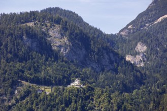 A, Hallstatt, A castle on a wooded mountainside surrounded by towering peaks, Austria