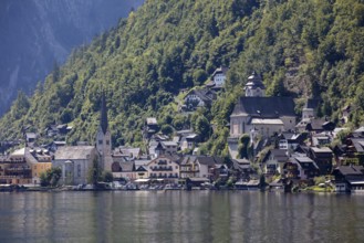 A, Hallstatt, A picturesque mountain village with lakeside churches in front of a steep forest