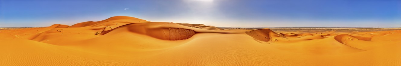 Panoramic view of vast orange sand dunes under bright skies, Sahara, Morocco