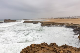 Stormy coastal scene with breaking waves and rocky landscape