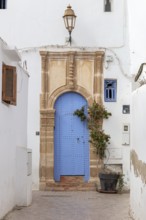 Decoratively designed blue door with a lantern above