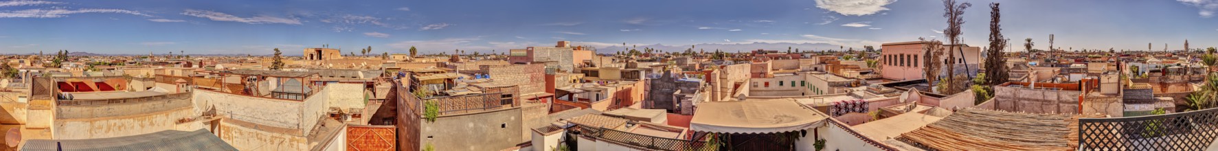 Panoramic view of the rooftops of Marrakech in Morocco under a blue sky with some clouds
