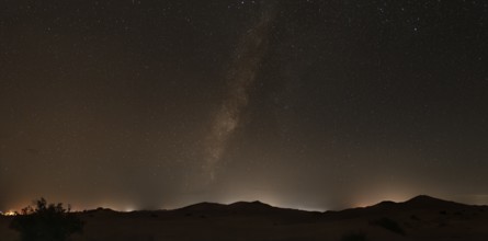 A clear night sky with the Milky Way over the tranquil desert landscape