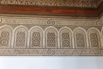 Complex arabesque patterns adorn a wall in a traditional style. Bahia Palace in Marrakech, Morocco