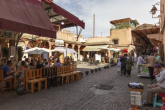 Friendly atmosphere in a street with open-air restaurants and people around tables