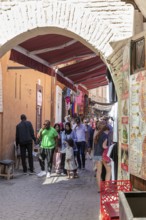 Passage in an old town with people and small shops, relaxed atmosphere