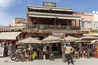 A café with a terrace where people sit and relax under umbrellas