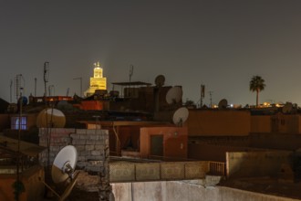 Night view in Marrakech with illuminated tower and satellite dishes