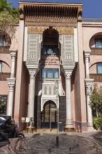 Decorated entrance façade of a building with columns and Moroccan ornaments