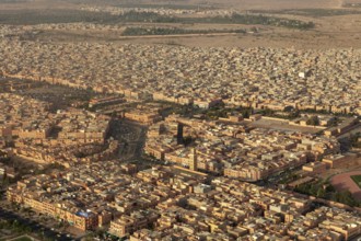 City view from the air with densely built orange buildings in a desert environment