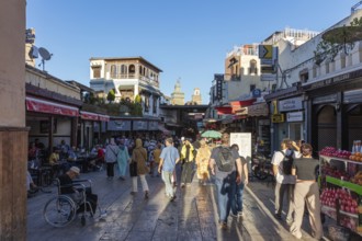 Bustling street with people and stands under a blue sky