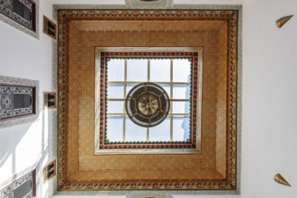 Ornately decorated ceiling with colorful mosaics and a large window