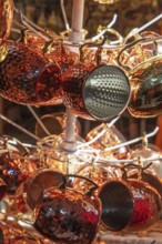 A collection of shiny copper cups and vessels presented at a stand