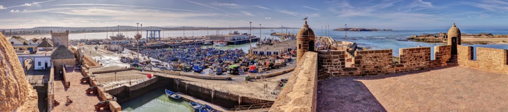 Extensive panorama of a harbor with boats and historic walls
