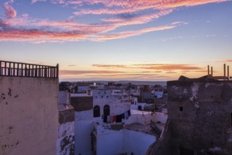 Romantic sunrise with purple clouds over the roofs of an urban environment