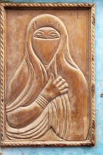 Wood carving depicting a veiled woman, traditional door design with blue border