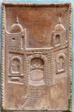 Wood carving of an architectural gate with traditional elements and two towers, traditional door