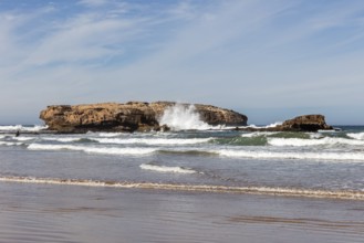 Rocky coast with breaking waves under clear sky