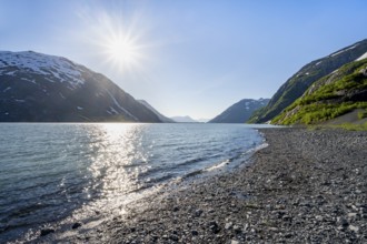Landscape on glacial lake Portage Lake with sun star, Chugach National Forest, Alaska, USA