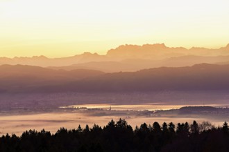 View from Horben of Lake Zug with the city of Cham and Zug covered in fog, behind it the