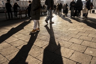 Passers-by on a sidewalk on Grunerstraße, near Alexander Platz, bus stop, in Berlin, shade, low
