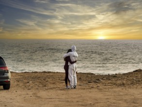 Young couple in love standing on the coast of Farol de Cabo Raso lighthouse, São Bras de Sanxete