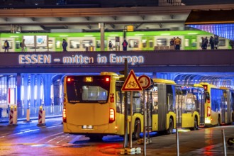 The main train station in Essen, blue illuminated underpass, bus station, am Europaplatz, train on