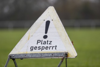Sign with the inscription PLACE BLOCKED on a sports field (symbol image)