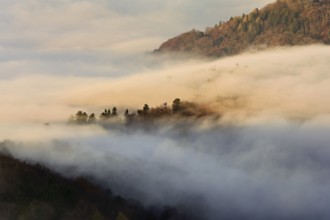 View from the Gisliflue of the Jurassic foothills covered in fog in the light of the rising sun,